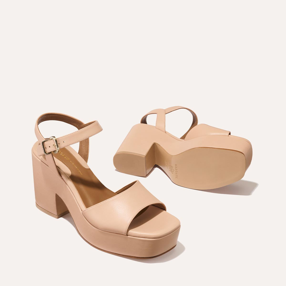 The Bardi - Petal Calf by margaux-development: nude chunky-heeled sandals with ankle straps and open toes. One shoe stands upright while the other lies on its side, revealing the sole against a plain, light background.