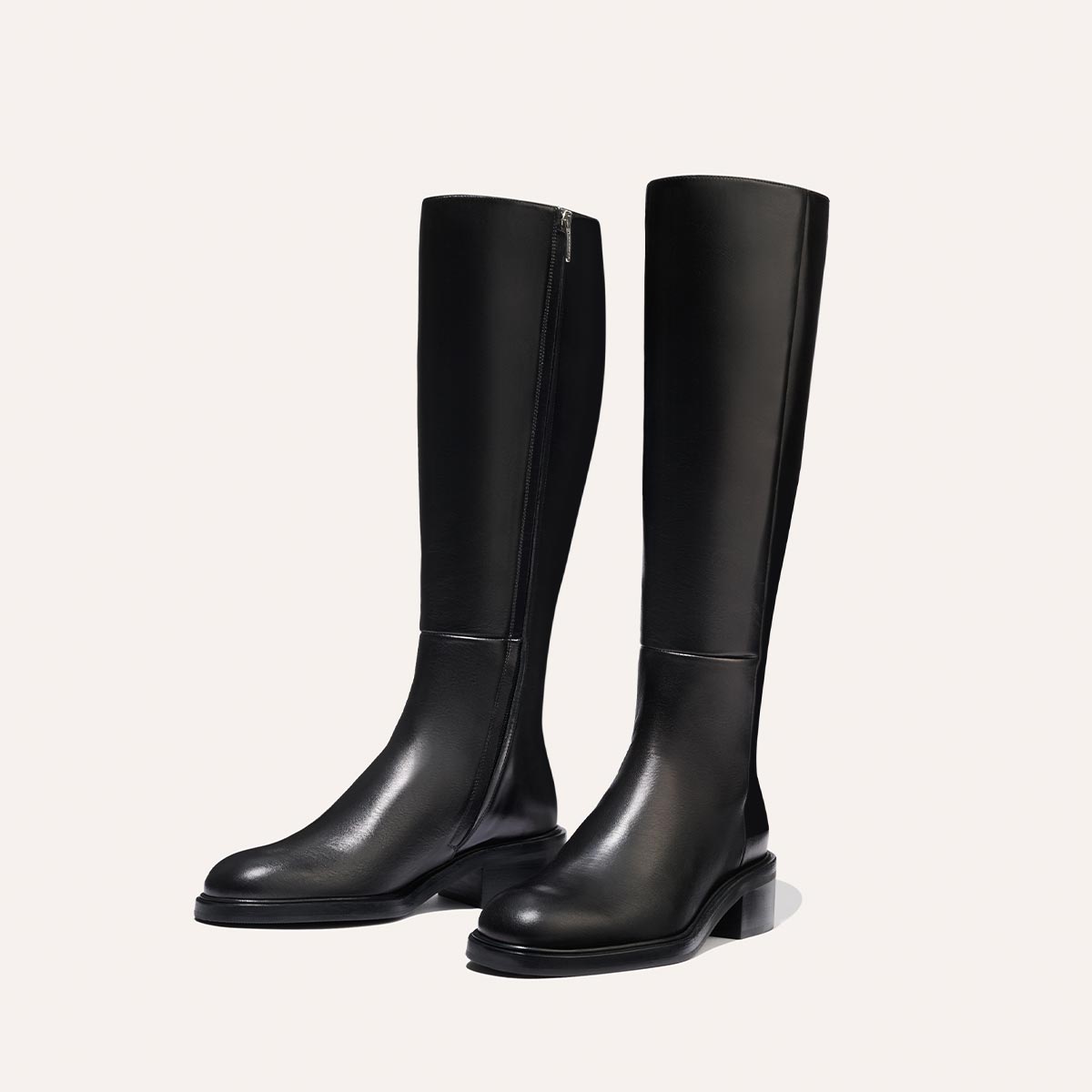 The City Boot - Black Calf by Margaux: sleek black riding boots with a classic silhouette, low heels, and side zippers, shown against a simple light background.