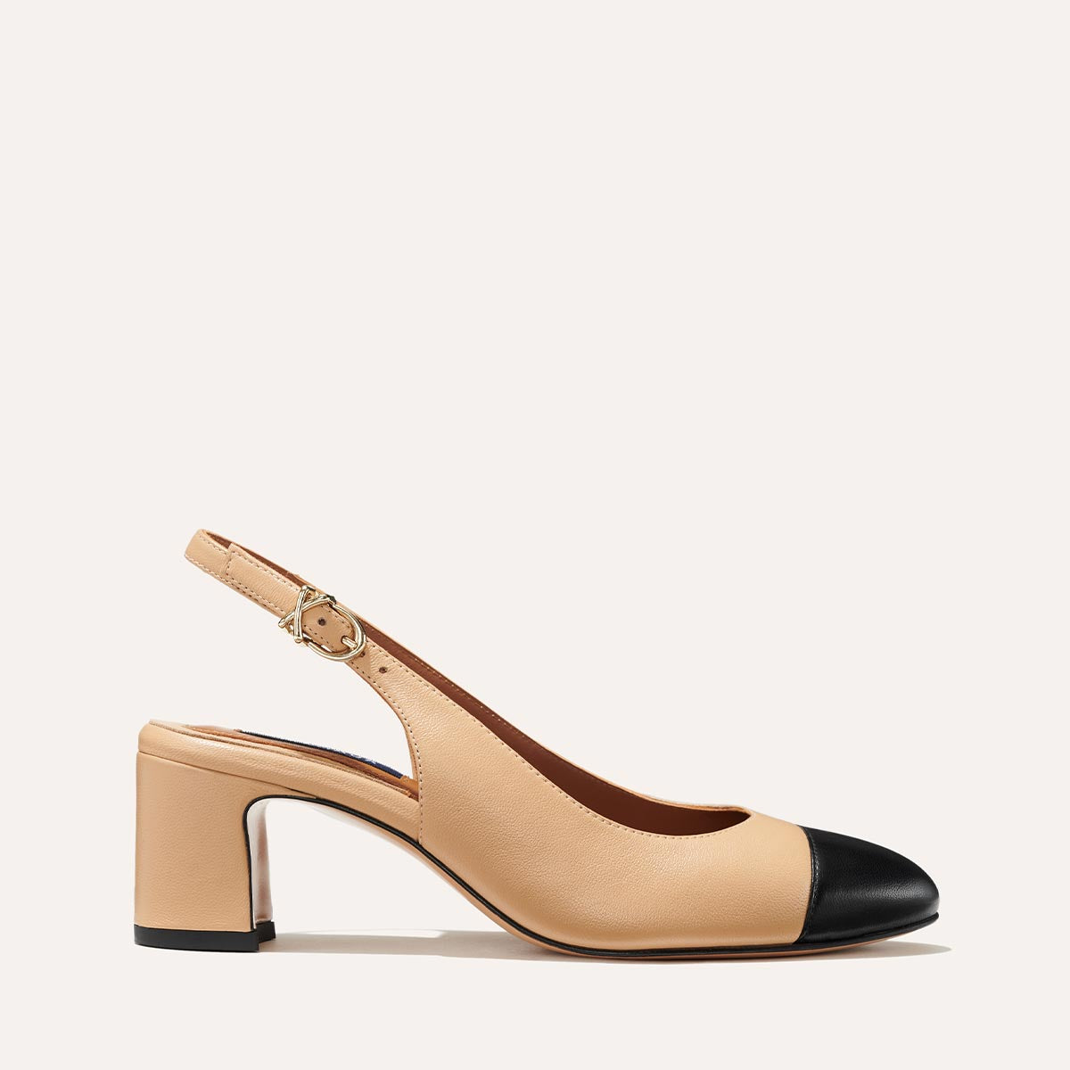 The Cluny Slingback in Dune Nappa, featuring a sleek captoe detail with an adjustable buckle and a comfortable 2.5-inch black heel.