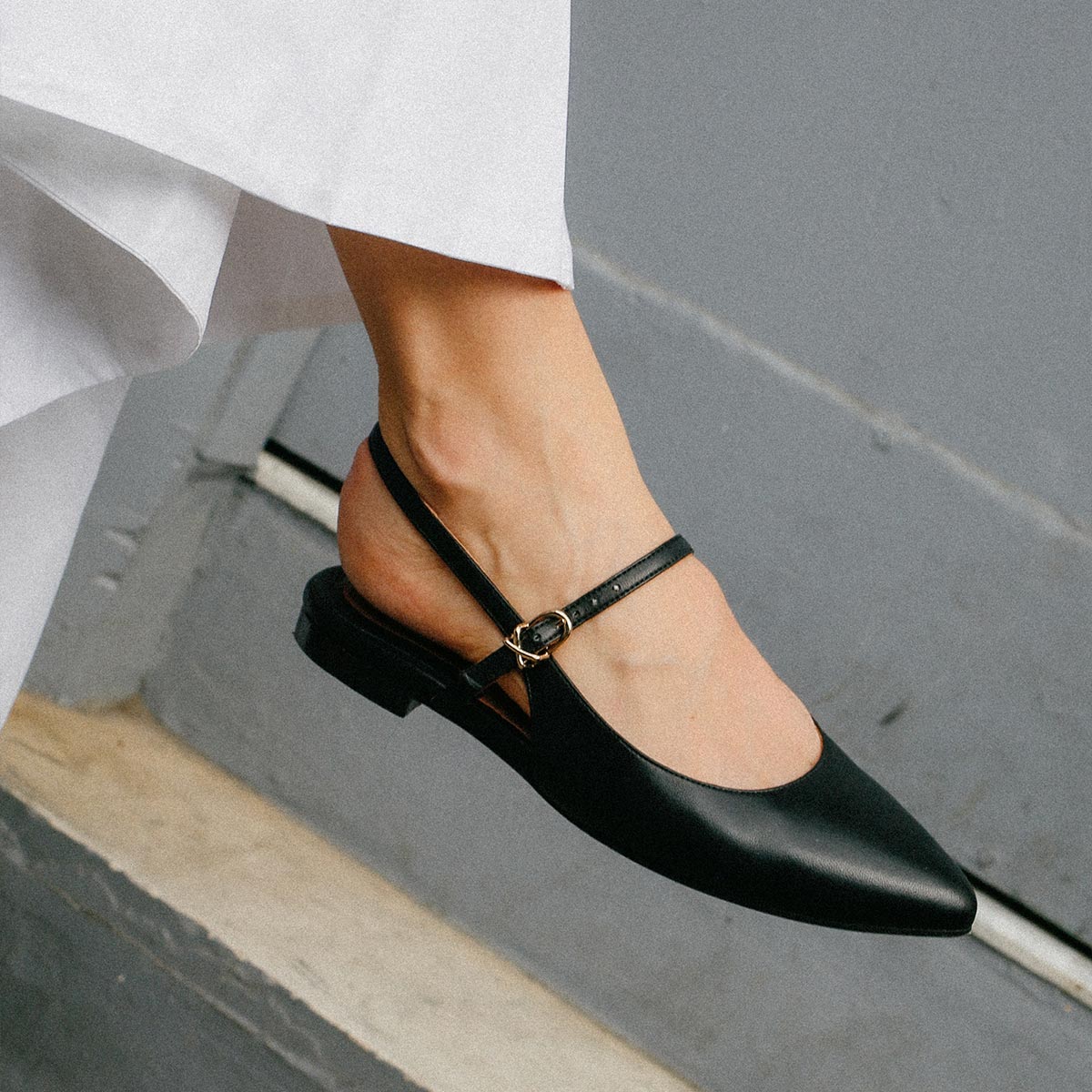 The Cluny Slingback in Black Nappa, a ballet flat with a pointed toe, a slingback strap and an adjustable strap across the top of the foot for a secure fit.