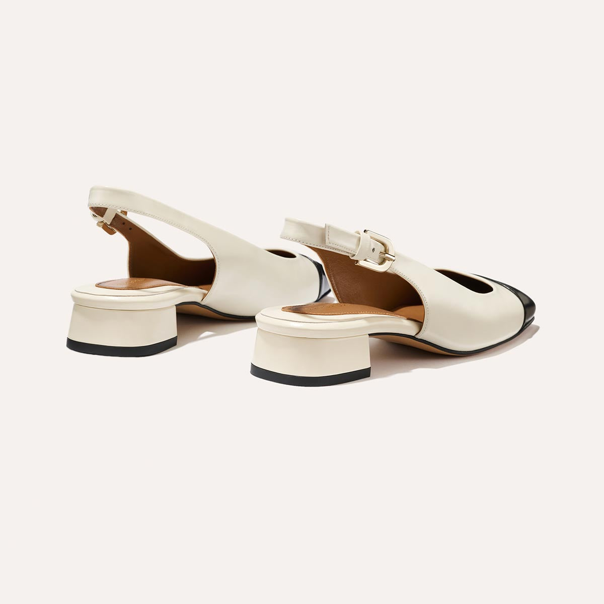 A cap toe low heel slingback with cream and black leather