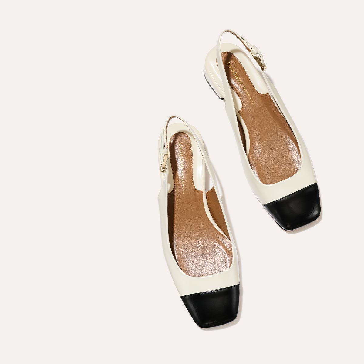 A cap toe low heel slingback with cream and black leather