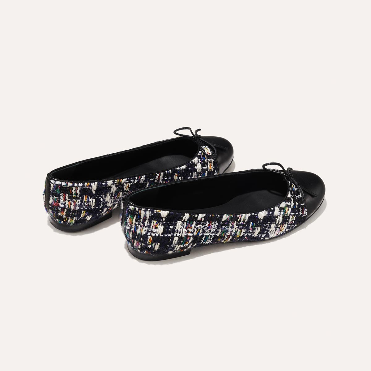 The Demi in Navy Tweed with a black cap-toe detail, a comfortable ballet flat with a rounded toe and adjustable cord bow detail.