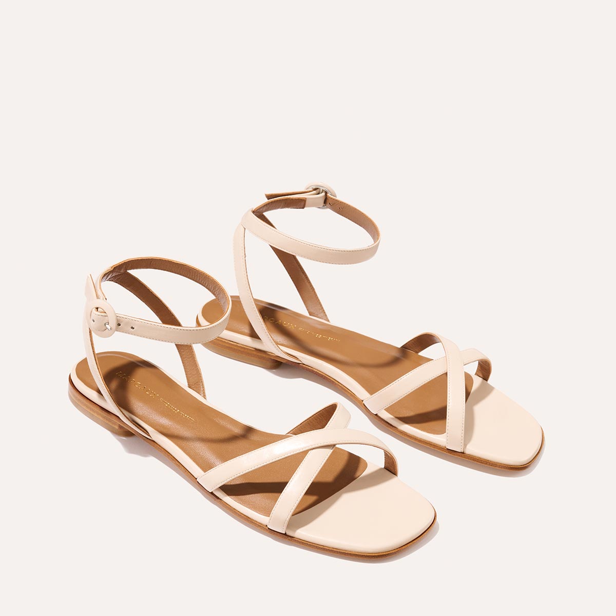 The Flat Sandal in magnolia nappa, a minimal sandal featuring thin, flattering straps with a subtly square toe.