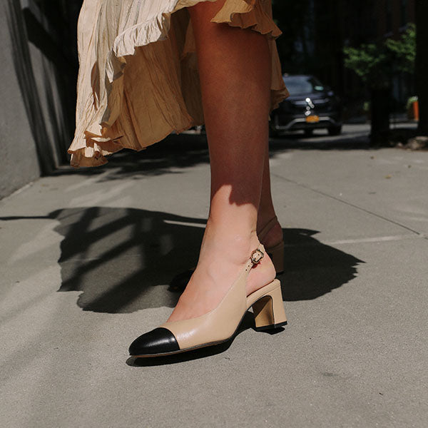 The Cluny Slingback in Dune Nappa, featuring a sleek captoe detail with an adjustable buckle and a comfortable 2.5-inch black heel.