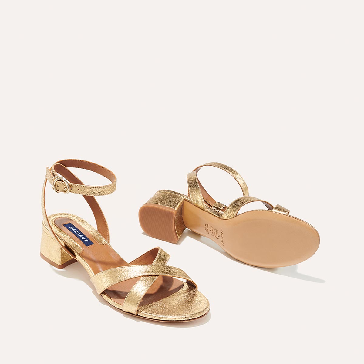The Lena Sandal in metallic Gold Crinkle Nappa, featuring perfectly placed straps around the ankle and toes and a comfortable 1.5-inch block heel.