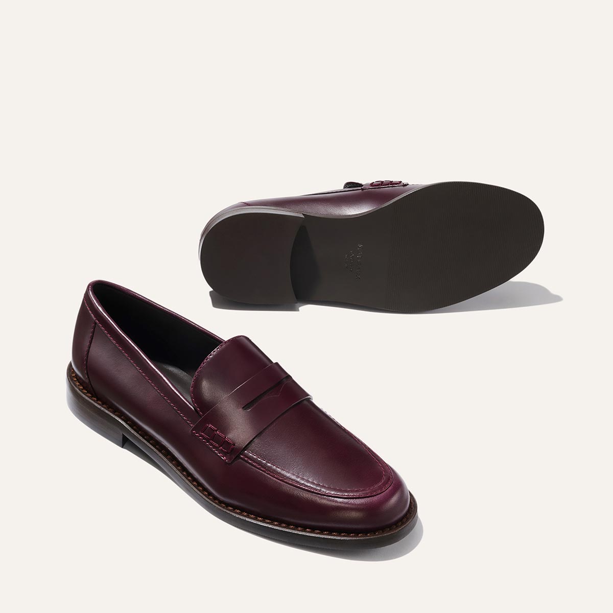 The Marlowe Loafer - Burgundy Calf by margaux-development: one shoe stands upright while the other lies on its side to reveal the dark sole, both displayed against a plain light background.