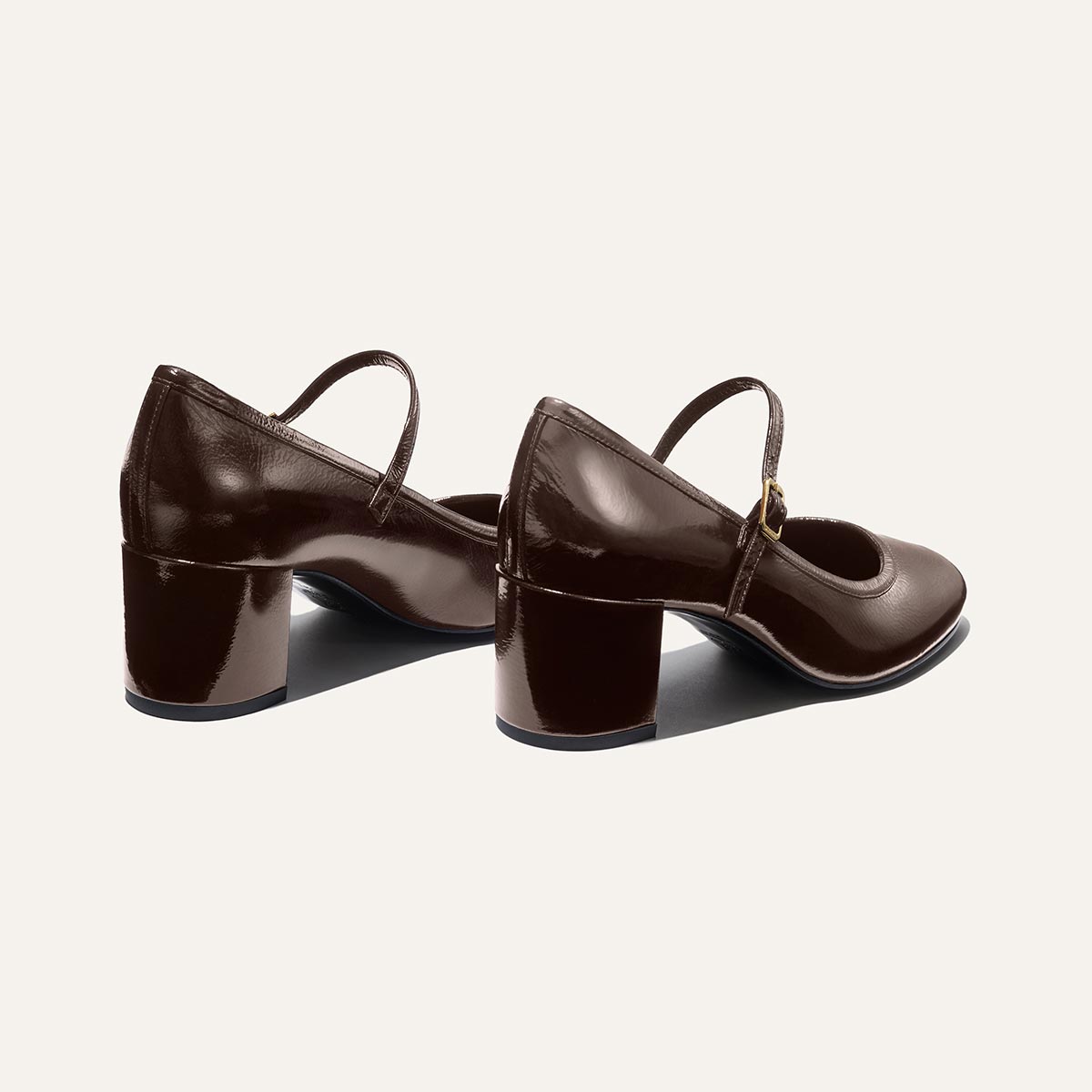 The Mira Jane - Cocoa Crinkle Patent by margaux-development: classic Mary Jane shoes in dark brown crinkle gloss patent with mid-height block heels and thin straps, shown on a light background.