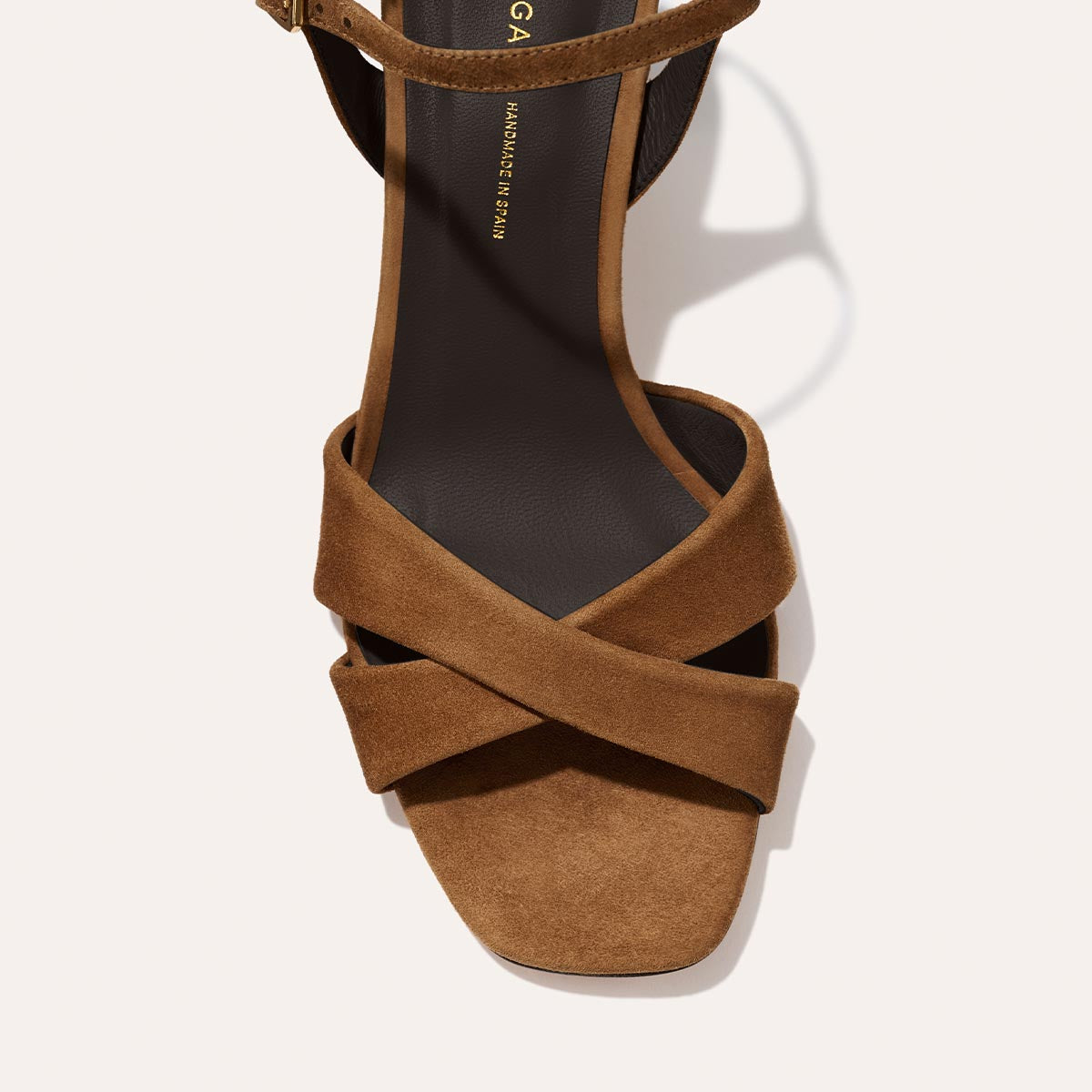 The Paloma Sandal by Margaux in Nutmeg Suede features thick leather crisscross straps, a dark insole, squared toe, and subtle 2.5-inch heel—a chic everyday sandal shown from above on a light background.