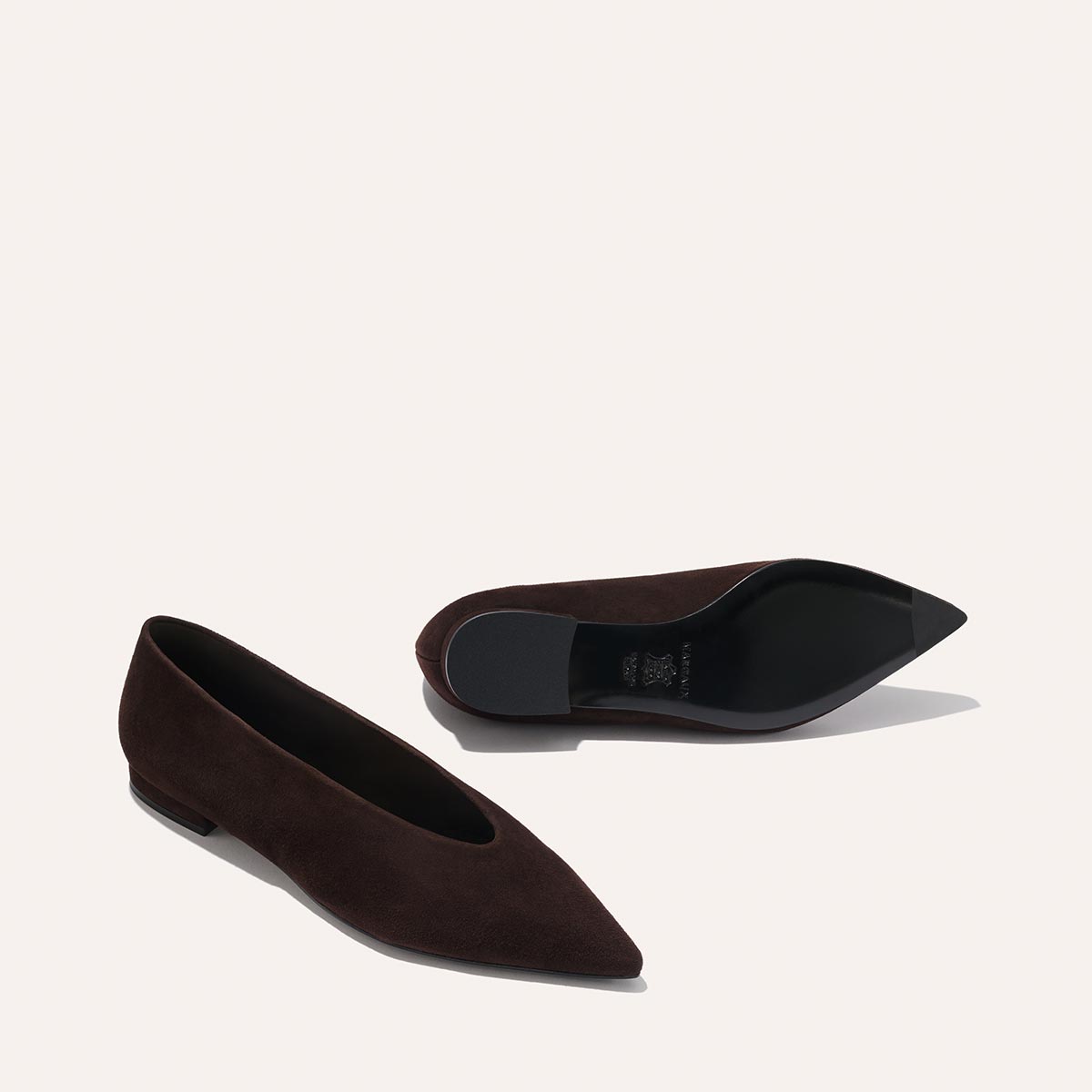 The Parra - Espresso Suede flats by margaux-development: a pair of dark brown suede pointed-toe shoes, with one upright and the other on its side displaying the black sole, set against a plain light background.