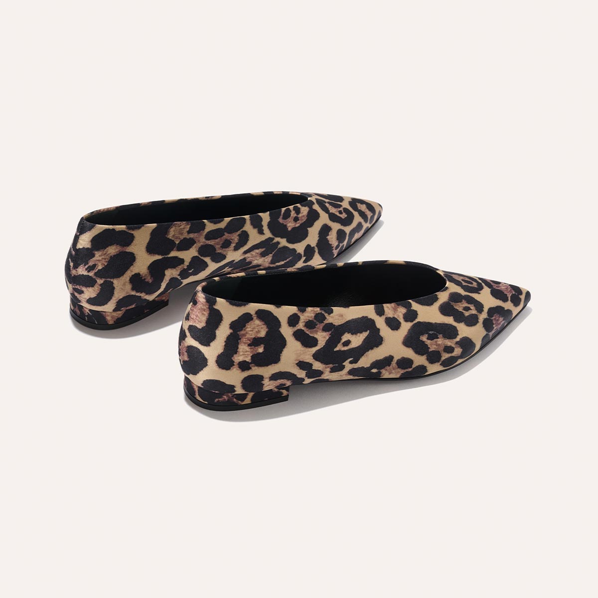 The Parra - Leopard Satin by margaux-development: pointed-toe flats in brown and black leopard print, displayed from a rear angled view on a light background.