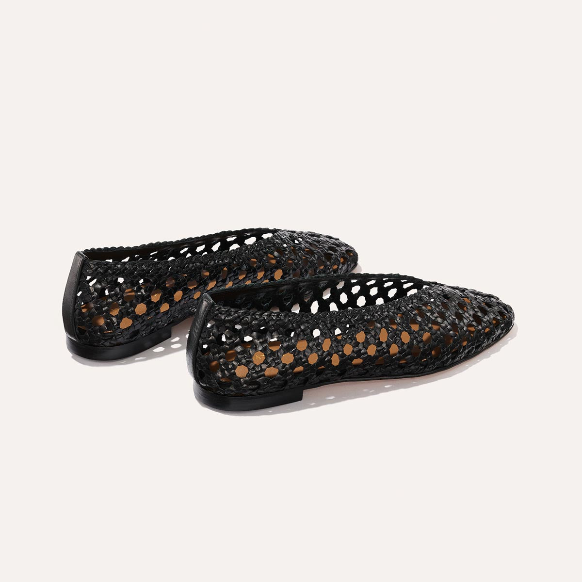 The Woven Paz - Black Leather flats by Margaux feature pointed toes and an open, perforated handwoven style, shown on a plain white background.