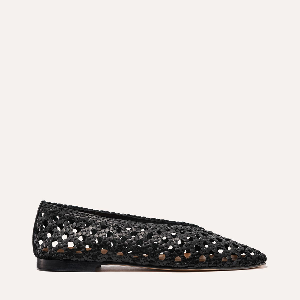 The Woven Paz by Margaux in black leather is a luxuriously soft flat with a pointed toe, low heel, and elegant perforated handwoven basket design, shown in profile against a plain light background.