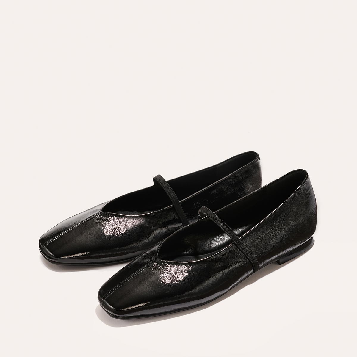 The Phoebe - Black Crinkle-Gloss Nappa by margaux-development: black, shiny square-toe ballet flats with thin straps and sacchetto construction for extra softness, shown on a plain light background.