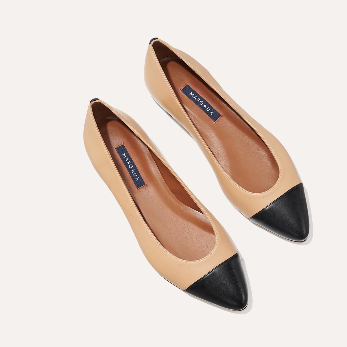 The Pointe in dune nappa, a classic and comfortable ballet flat featuring a refined pointed toe design and nappa leather cap-toe detail.