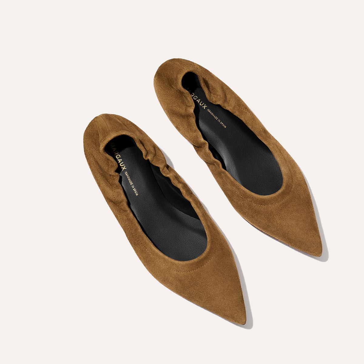The Roma - Cedar Suede by Margaux: brown pointed-toe suede ballet flats with gathered detailing, shown on a light background. Black insoles feature subtle gold branding for a refined update to the classic ballet flat.