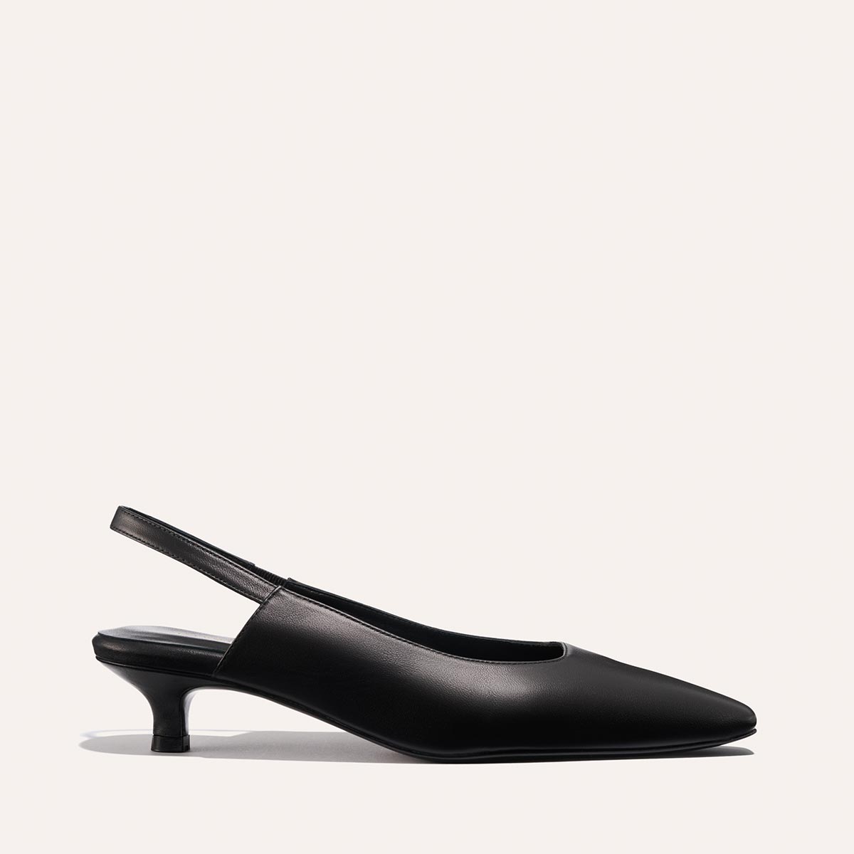 The Sofia Sling - Black Nappa by margaux-development features a black snip-nose slingback design with a low micro heel, shown against a plain off-white background.