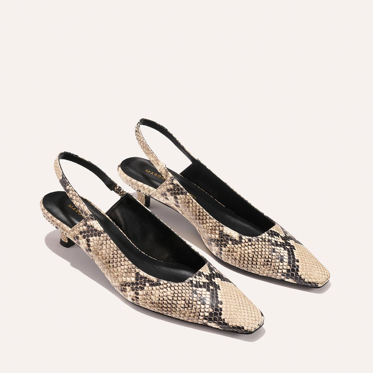 The Sofia Sling - Natural Python Embossed by Margaux features a striking snakeskin pattern, snip nose pointed toes, low micro heels, and black inner soles, making these womens slingback heels stand out on a light background.