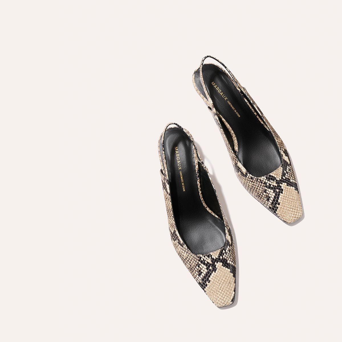 Margaux’s The Sofia Sling in Natural Python Embossed features a pointed toe, chic micro heel, and beige-black snakeskin pattern—perfectly displayed on a light background.