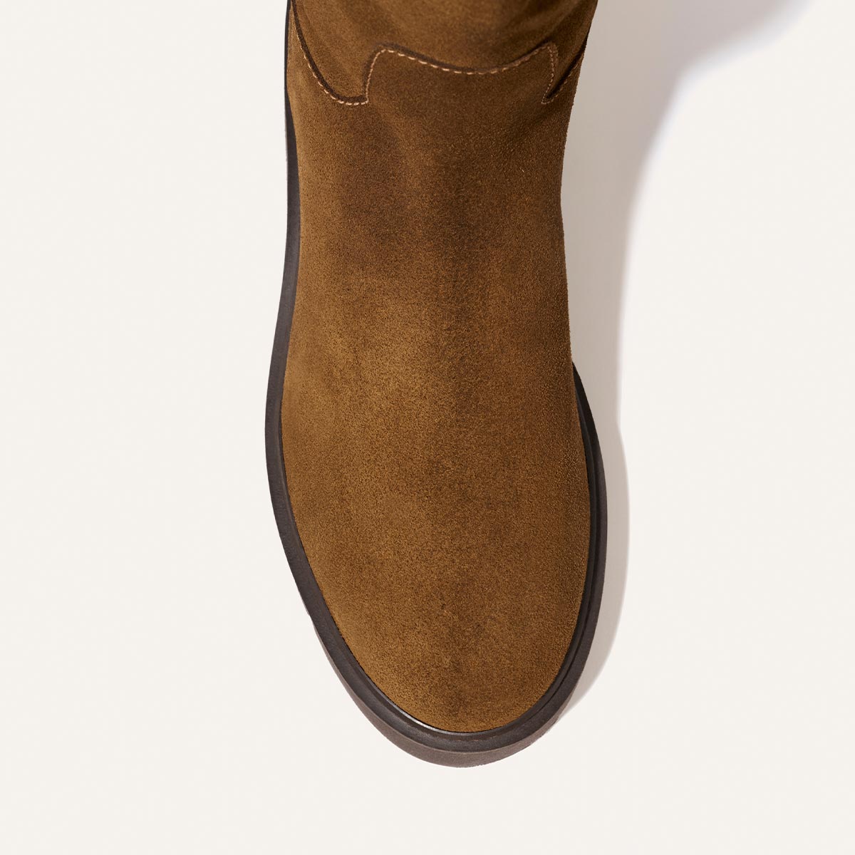 Top-down view of The Wells Boot in Cedar Suede by Margaux, featuring a rounded toe and a black rubber sole, displayed on a light background.