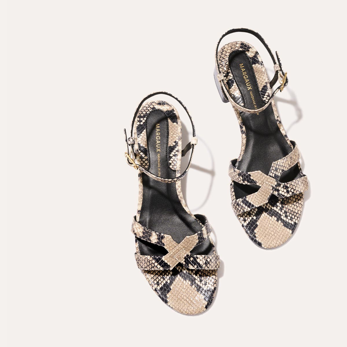 Low heeled sandals shown in natural embossed python