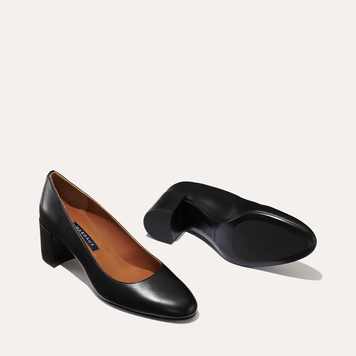 The Heel in Black Nappa, a classic block heel featuring a sleek almond toe design complemented by a comfortable 2.5-inch heel.