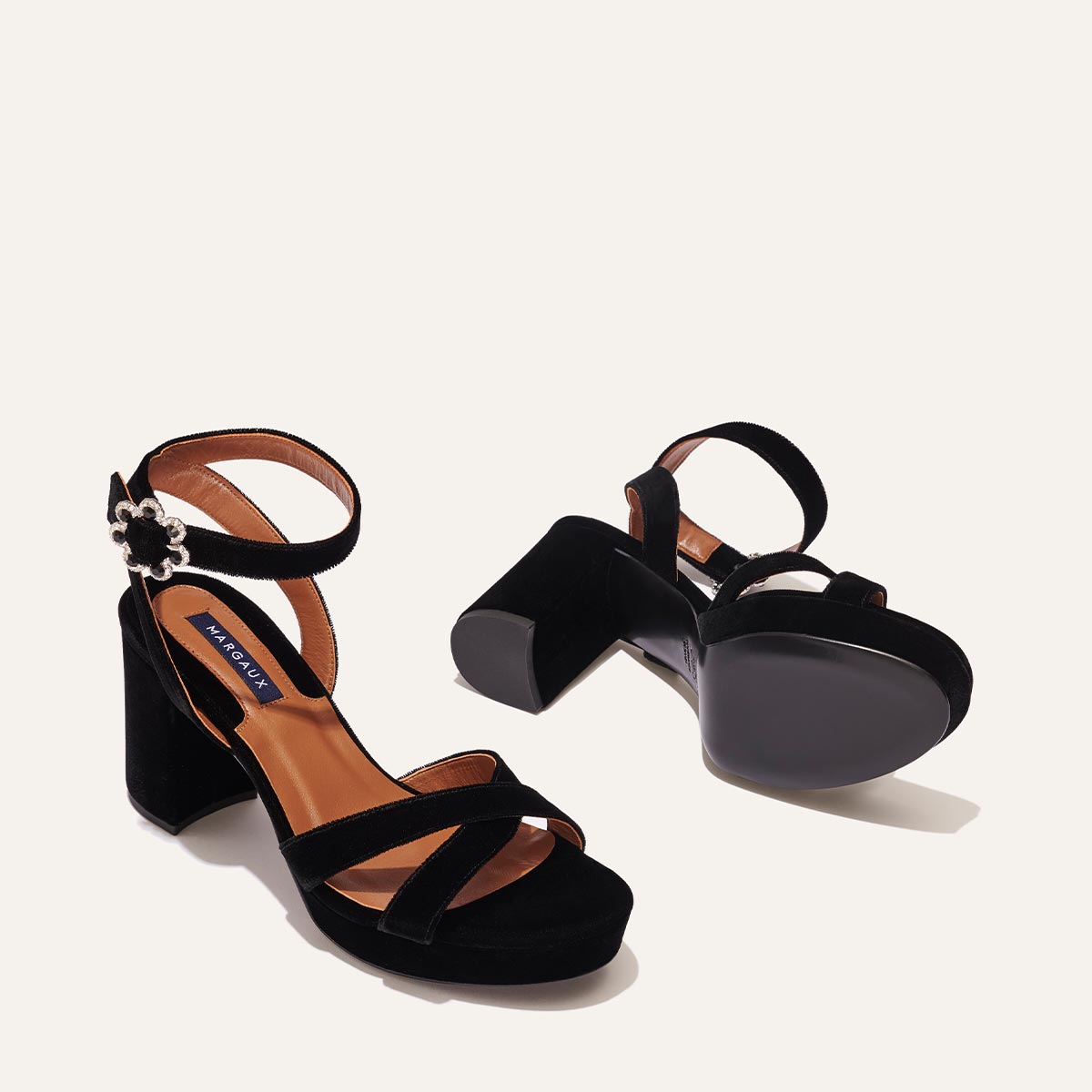 The Platform Sandal - Black Velvet by margaux-development features ankle straps and a silver buckle, shown on a light background with one sandal upright and the other on its side to display the sole and comfortable heel height.