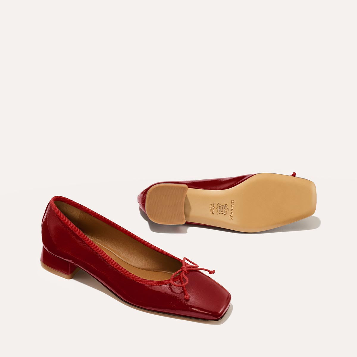 The Ada in Berry Crinkle Patent, a comfortable ballet flat with a square toe, adjustable cord bow detail, and comfortable 1-inch block heel.