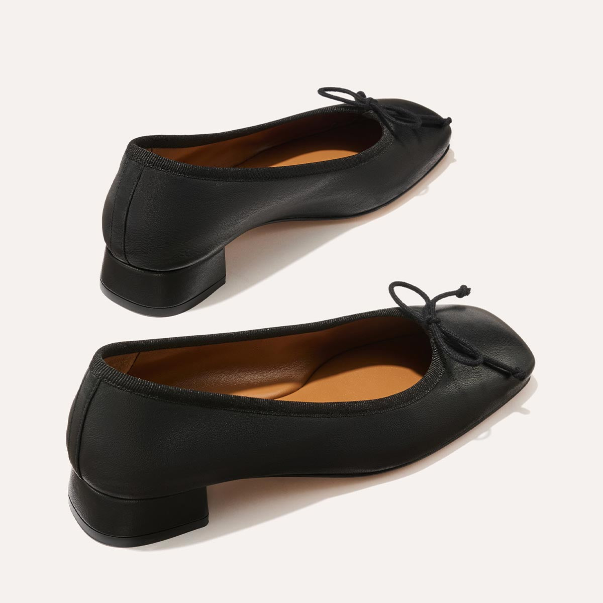 The Ada in Black Nappa, a comfortable ballet flat with a square toe, adjustable cord bow detail, and comfortable 1-inch block heel.