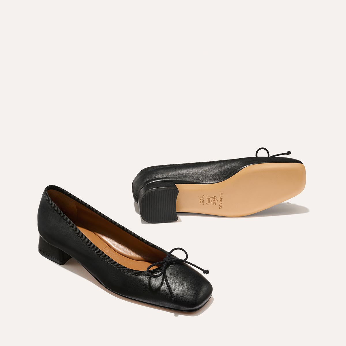 The Ada in Black Nappa, a comfortable ballet flat with a square toe, adjustable cord bow detail, and comfortable 1-inch block heel.