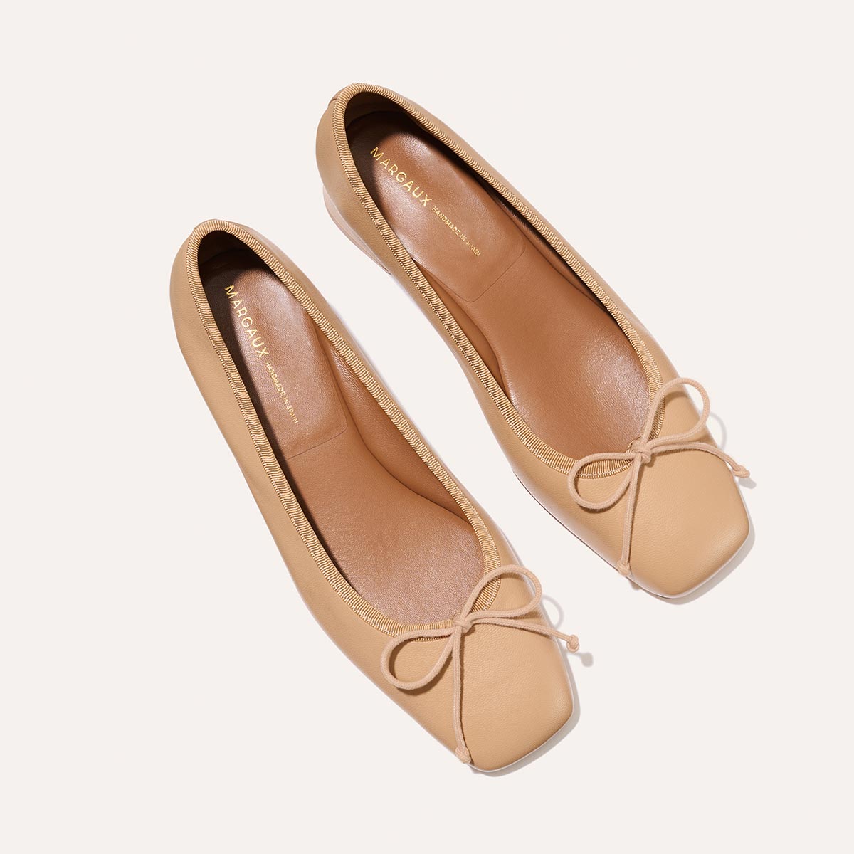 The Ada in Dune Nappa, a comfortable ballet flat with a square toe, adjustable cord bow detail, and comfortable 1-inch block heel.