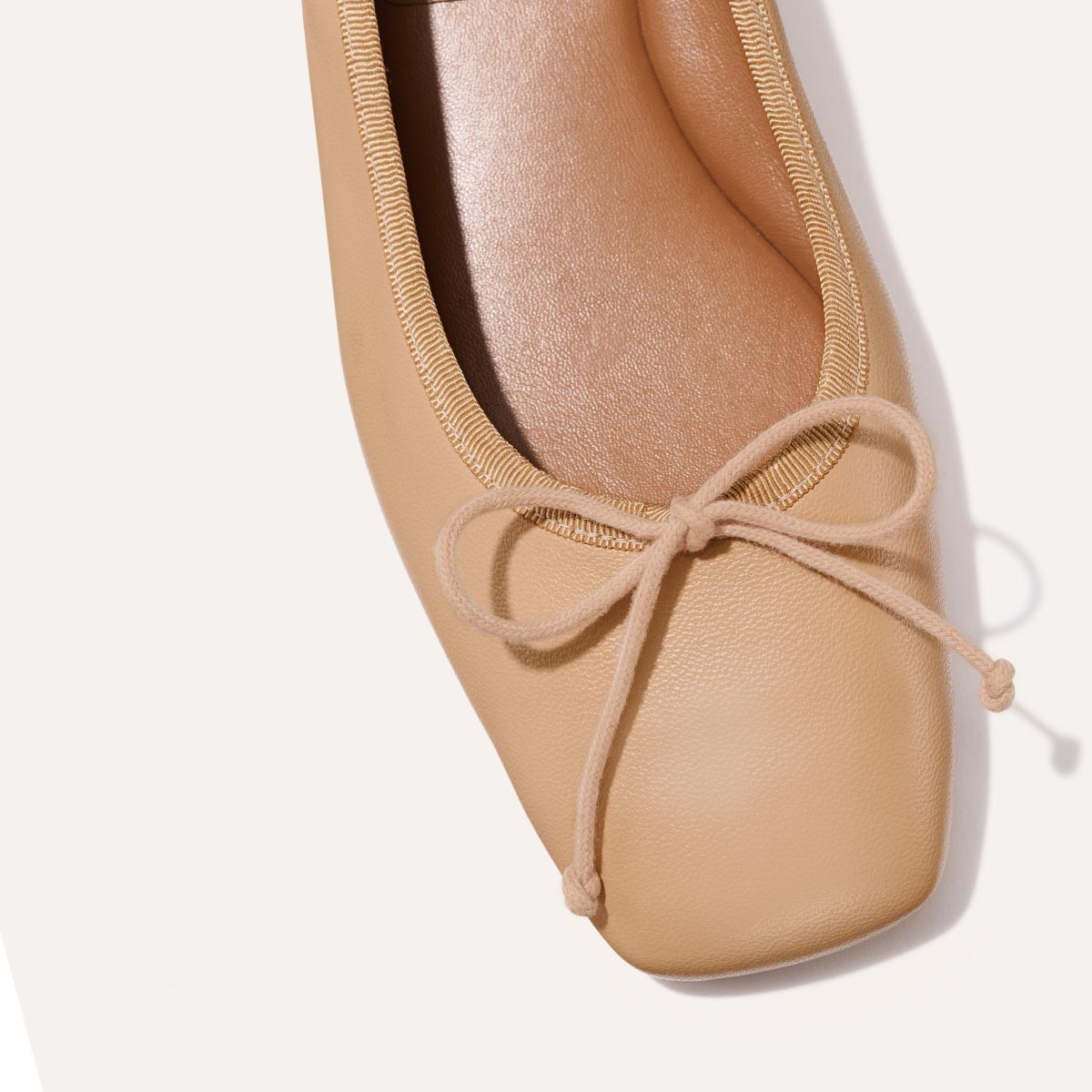 The Ada in Dune Nappa, a comfortable ballet flat with a square toe, adjustable cord bow detail, and comfortable 1-inch block heel.