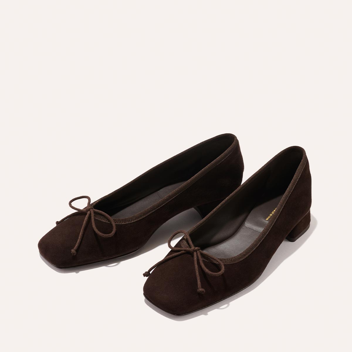 The Ada - Espresso Suede by margaux-development: dark brown suede ballet flats with square toes, low block heels, bow detail, and sacchetto construction for a glove-like fit, shown on a light background.
