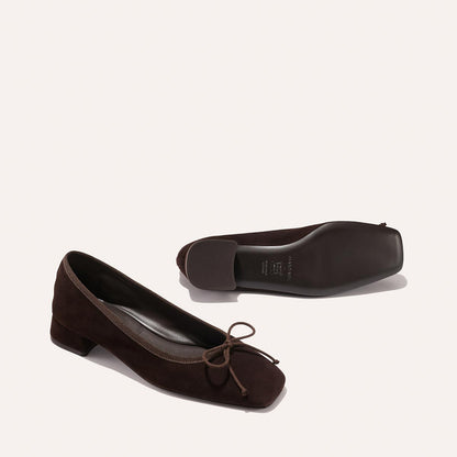 The Ada - Espresso Suede by margaux-development: low-heeled dark brown suede ballet pumps with bow details and sacchetto construction for a glove-like fit. Shown upright and on its side to display the sole, set against a light background.