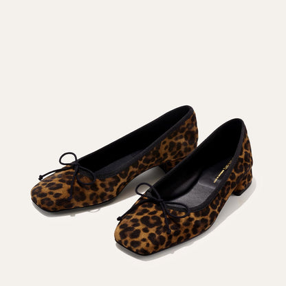 The Ada - Leopard Suede by margaux-development: women’s low-heeled ballet pumps with a square toe, brown and black leopard print, black bow detail, and a glove-like fit—shown against a plain light background.