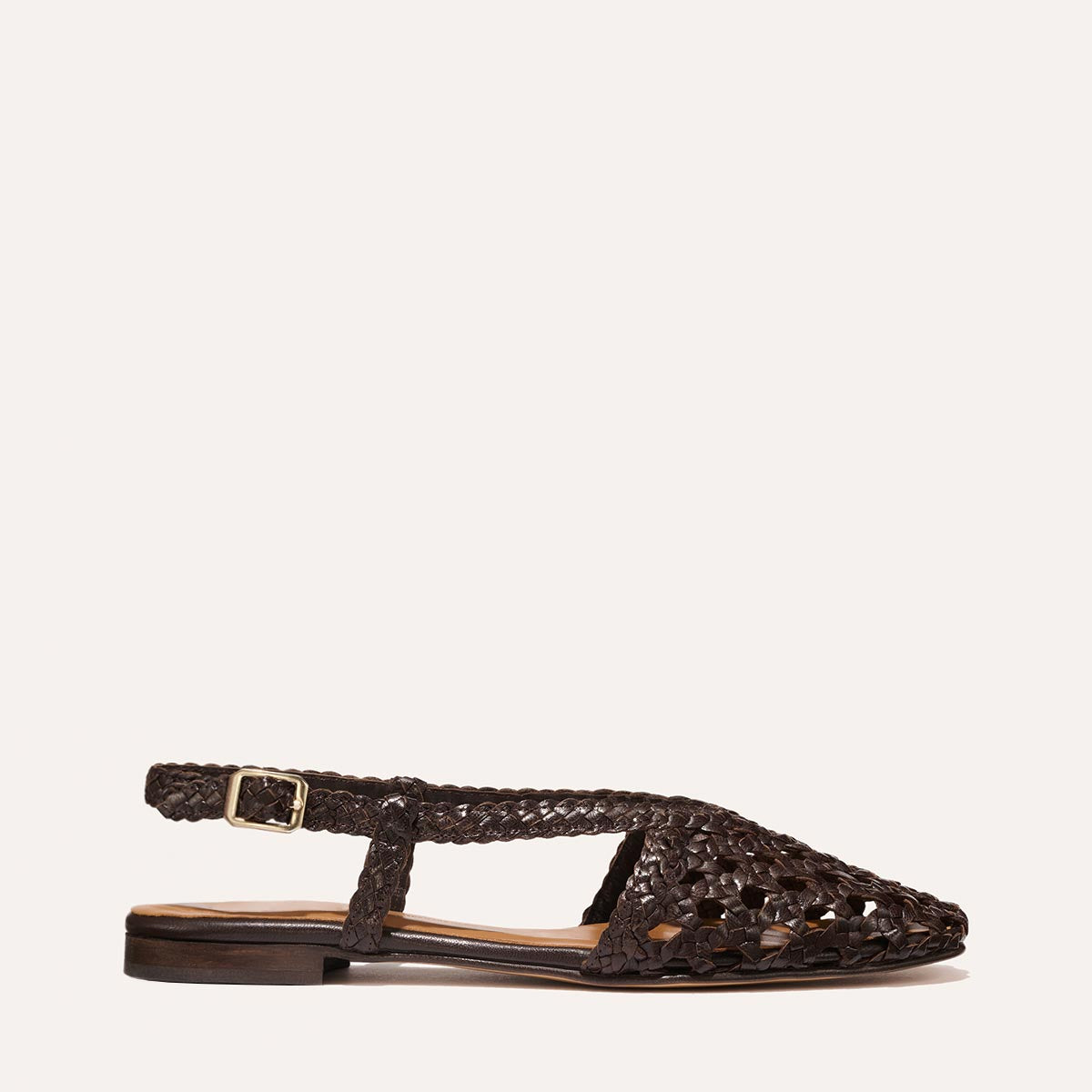 The Altea - Espresso Woven Leather by Margaux is a dark brown summer flat with a pointed toe, open sides, and an adjustable buckle strap, shown on a light background.