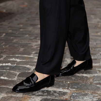 The Andie Loafer in shiny Black Patent, featuring a sleek structured design made from smooth Italian nappa leather with a minimalistic padded keeper detail.