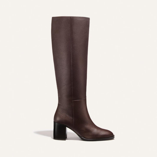 Introducing the Alison Roman x Margaux: The Charlie Boot - Brown Tumbled Calf by Margaux—a single knee-high boot in brown tumbled calf leather, featuring a rounded toe and sturdy block heel, showcased against a plain white background. This is the tallest boot in the collection.