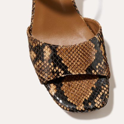 The Bardi - Camel Python Embossed by margaux-development features a brown and black snakeskin pattern, open toe, and sleek platform heel—perfect for adding modern style to any look.