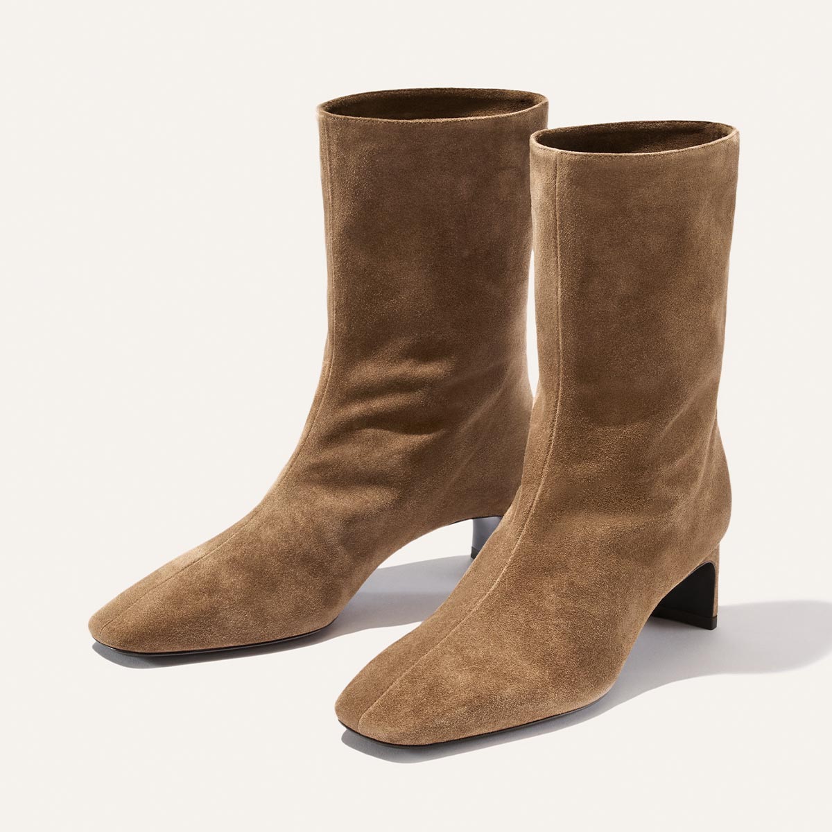 The Brera Boot - Driftwood Suede by Margaux: a pair of tan suede ankle boots featuring a square toe and a low, angled heel, showcased against a plain light background.