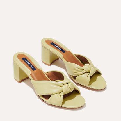 The Carmine Mule in Pear Nappa, a slide-on heel featuring a plush knot detail and comfortable 2.5-inch block heel