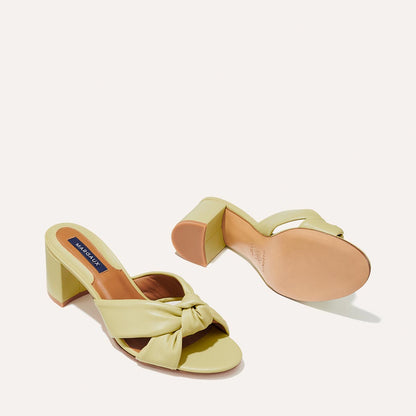 The Carmine Mule in Pear Nappa, a slide-on heel featuring a plush knot detail and comfortable 2.5-inch block heel