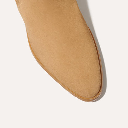 Close-up of the toe of Margaux's The Chelsea Boot in Sand Suede, featuring a rounded point and light brown sole, photographed against a white background.