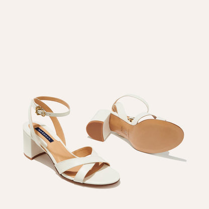 The City Sandal in Ivory Nappa, featuring carefully placed straps, and adjustable ankle strap and a comfortable 2.5-inch block heel.