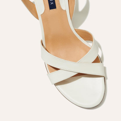 The City Sandal in Ivory Nappa, featuring carefully placed straps, and adjustable ankle strap and a comfortable 2.5-inch block heel.