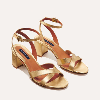 The City Sandal in metallic Gold Nappa, featuring carefully placed straps, and adjustable ankle strap and a comfortable 2.5-inch block heel.