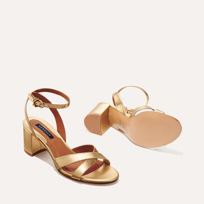 The City Sandal in metallic Gold Nappa, featuring carefully placed straps, and adjustable ankle strap and a comfortable 2.5-inch block heel.