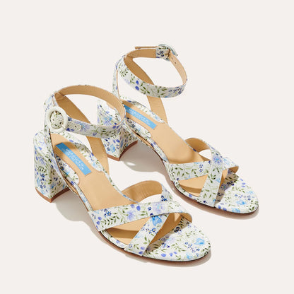 The City Sandal - Ivory Floral Satin by margaux-development features block heels, ankle straps with buckles, a white base with blue and green floral print, and a cushioned insole for comfort.