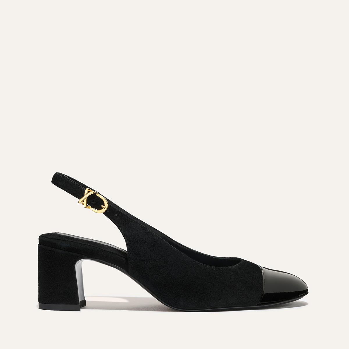 Margaux’s The Cluny Slingback in black suede and patent features a mid-height block heel, shiny toe cap, gold buckle strap, and elegant style—perfect work shoes set against a plain light background.
