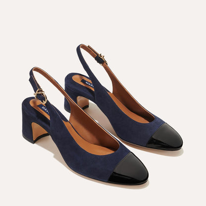 The Cluny Slingback in Navy Suede, featuring a sleek patent captoe detail with an adjustable buckle and a comfortable 2.5-inch black heel. 